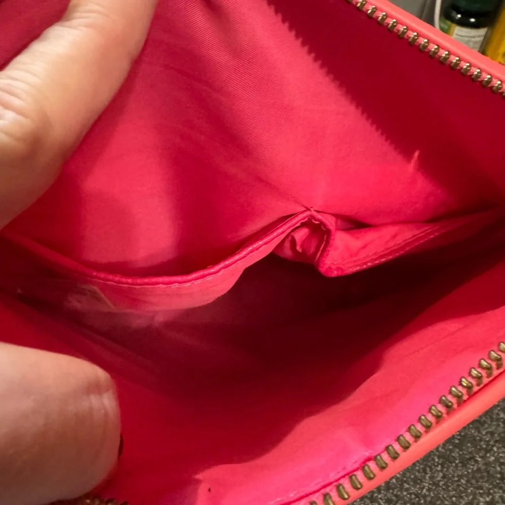 Pink cosmetics bag with 🐝 emblem. Has two inside pockets.